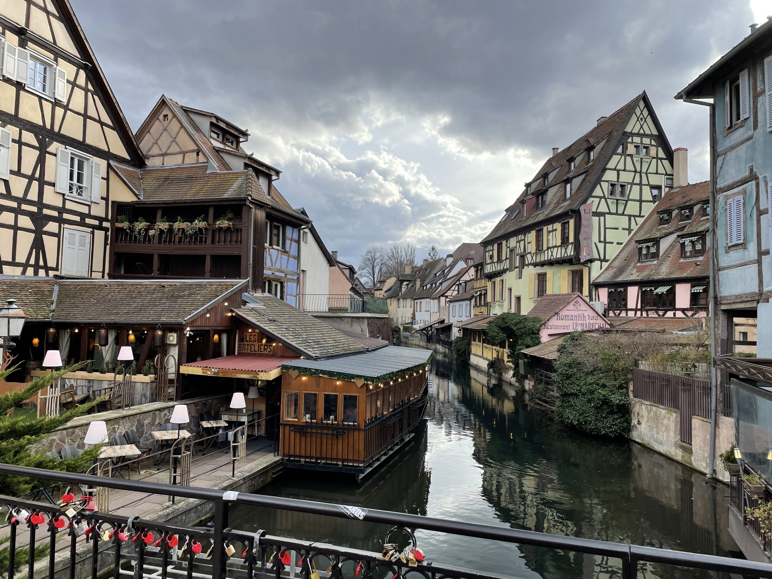 a smal river flanked by fairytale-like buildings in Colmar France