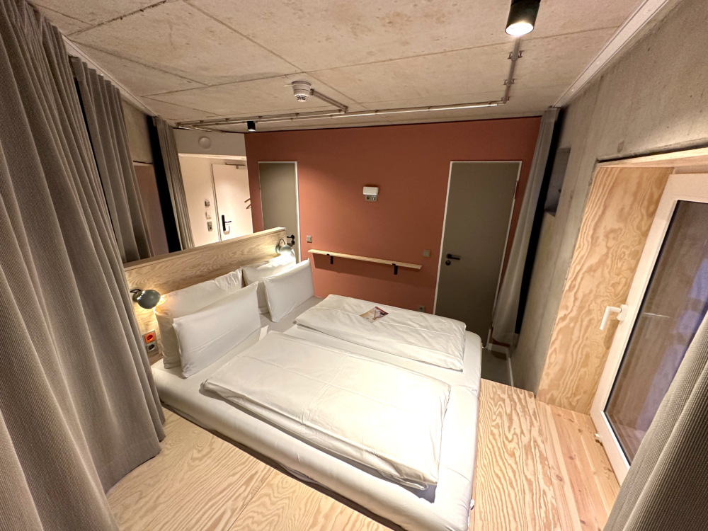 Overhead view of a stylish bedroom at Villa Viva Hotel in Hamburg with cozy bedding and contemporary decor.