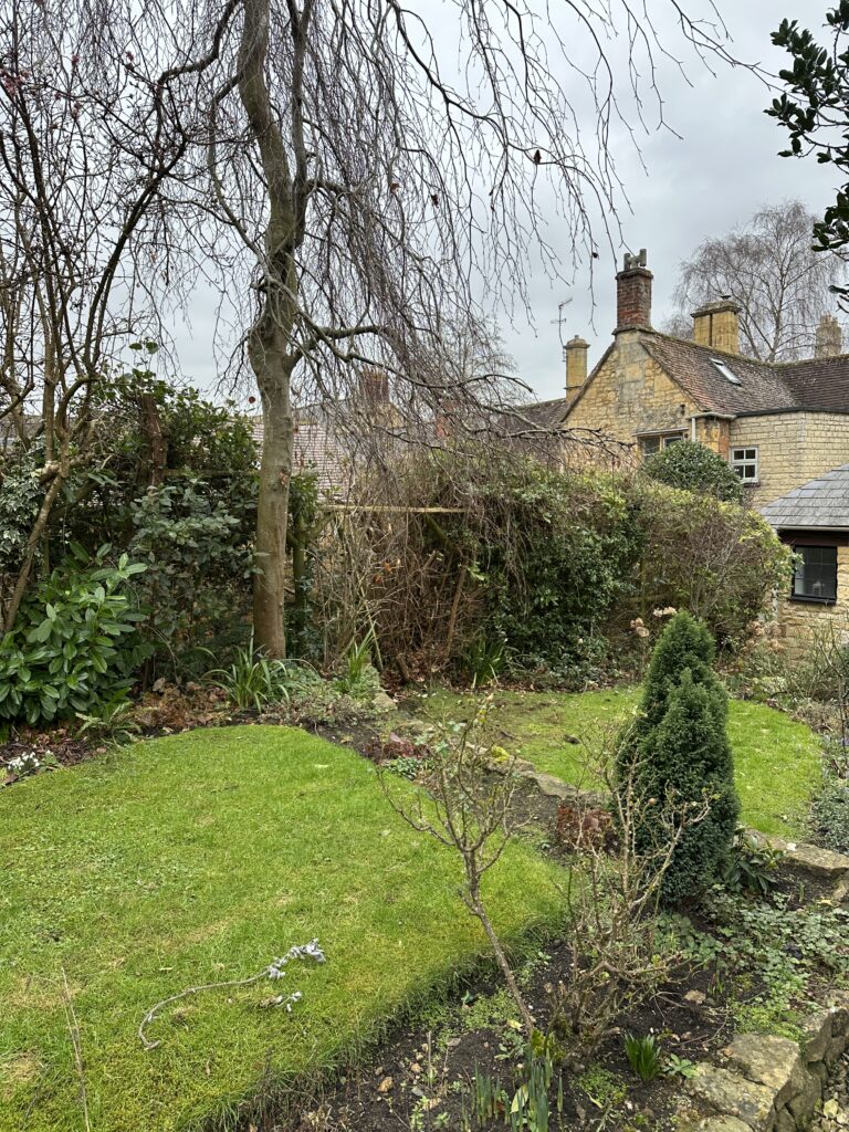 Peaceful garden area at Lane’s Cottage in the Cotswolds, surrounded by traditional honey-colored stone cottages.