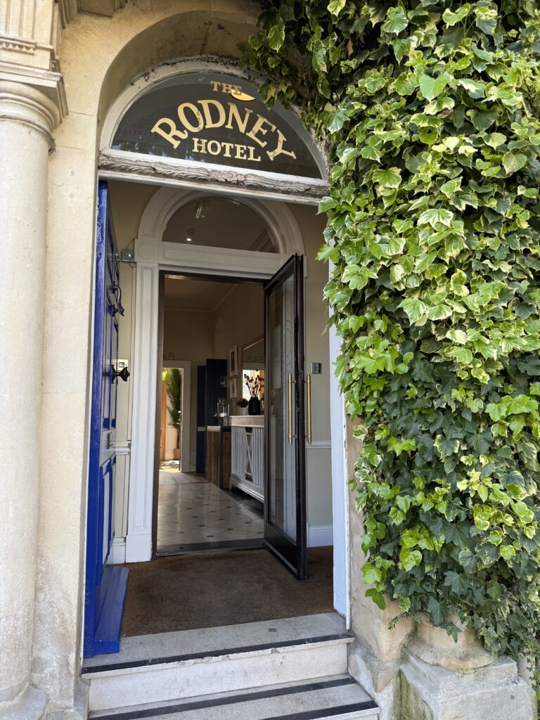 IMG_8116 The Rodney Hotel entrance in Bristol, England featuring an arched doorway, ivy-covered exterior, and a view into the lobby